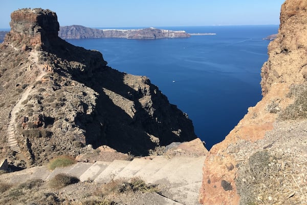 Une côte accidentée, avec une falaise abrupte et un sentier étroit qui descend.