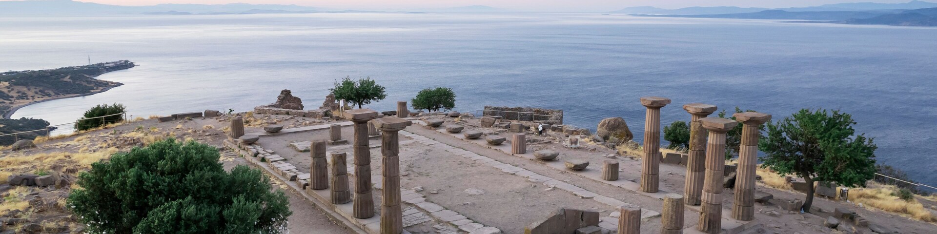 Ruinas antiguas con columnas y vista al mar.