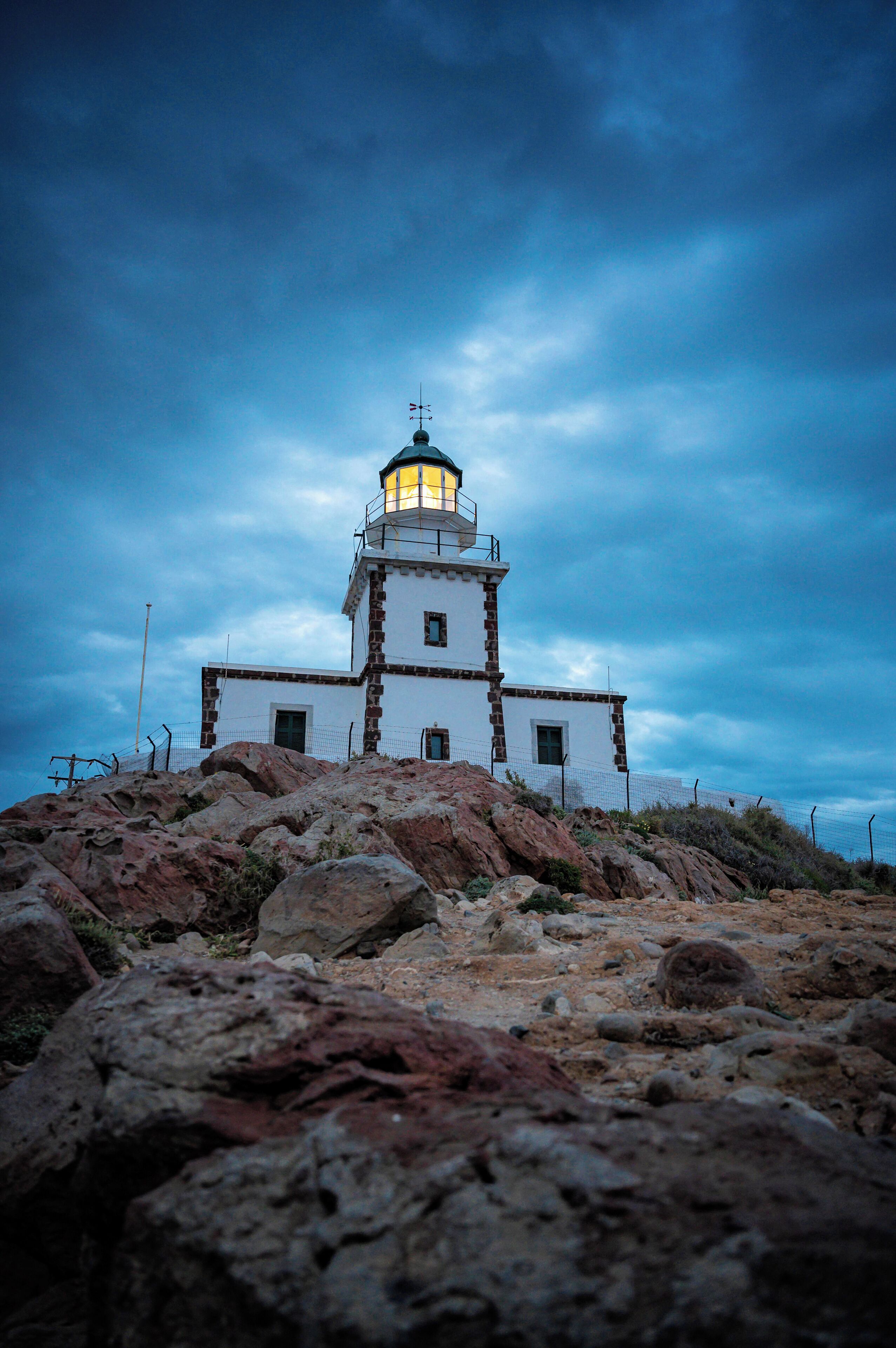 In the lovely, tranquil village of Akrotiri you can find the well-known lighthouse located on the extreme southwest part of the island, 18 kilometers away from the capital of Santorini. It is considered one of the best and most beautiful lighthouses in Cyclades. Attuned to the rest of the island, it is an admirable building with whitewashed walls standing on the edge of a high cliff right above the sea. It is, by all means, an idyllic setting.
The Akrotiri lighthouse, which was manufactured by a French company in 1892, is among the first lighthouses in Greece. It stopped operating during World War II but started again in 1945 with a reconstruction by the Greek Navy. Originally it was powered by petrol fuel until 1988 that it became automatic. The tower above the lighthouse keeper’s house is 10 meters high and emits a luminous white light.
There is no public access inside the building but you can relish it, together with a fascinating view, by sitting on its exterior stone wall or on the rocks by the sea all around. The lighthouse is easily accessible by road from Akrotiri village and the route suggests magnificent images.
#Greece #Santorini #Culture #Cyclades #Trovember