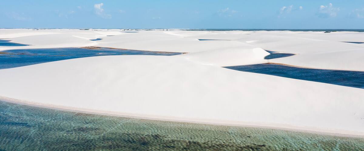 White sand dunes with clear blue water channels.