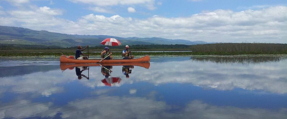 A calm lake with a canoe and an umbrella.