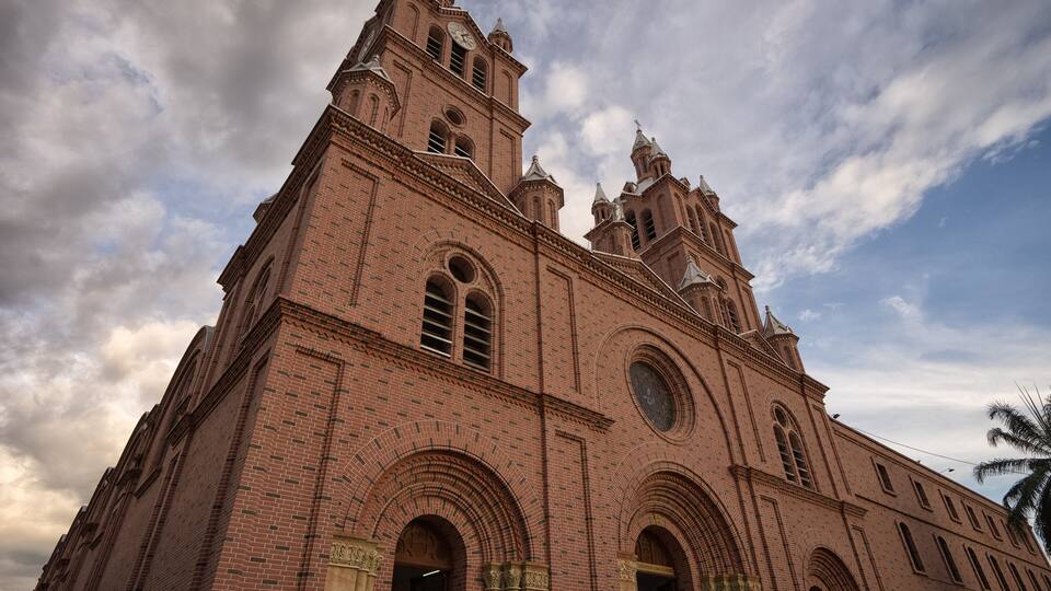 A large brick church with multiple towers and arched windows.