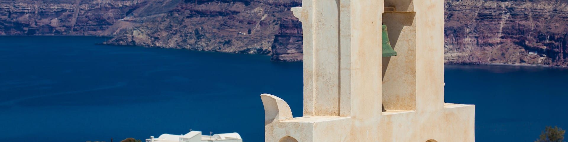 View of the Aegean sea and a traditonal bell tower from the ruins of the Castle of Akrotiri also known as Goulas or La Ponta, a former Venetian castle on the island of Santorini