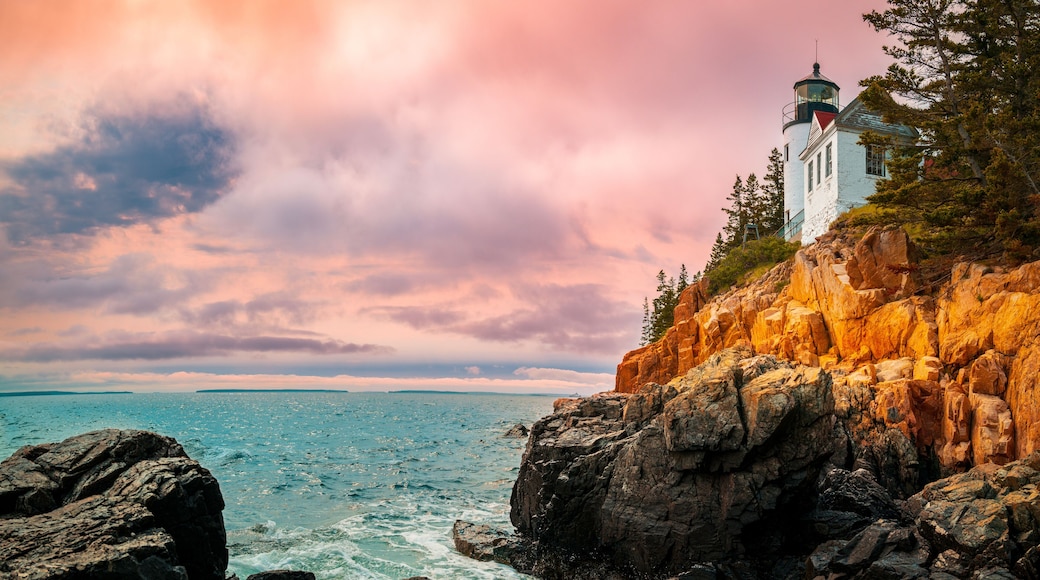 Sunset over the lighhouse on the cliff. Dramatic seascape with Bass Harbor Head Light Station in Tremont, Acadia National Park, Maine
