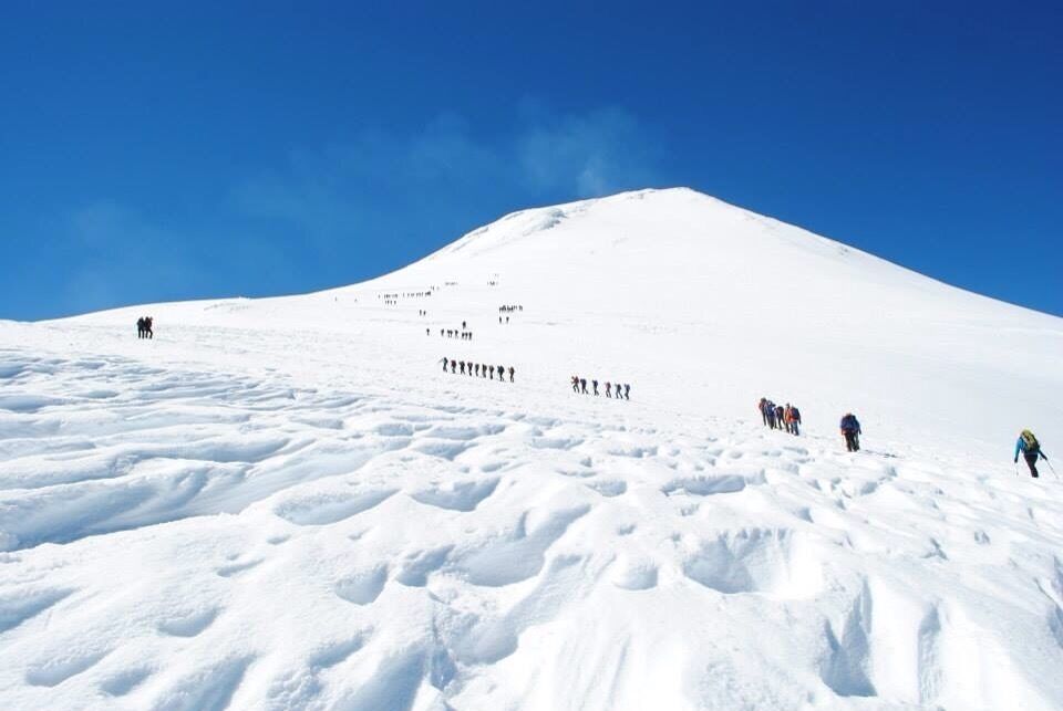 A snow-covered mountain with a clear blue sky.