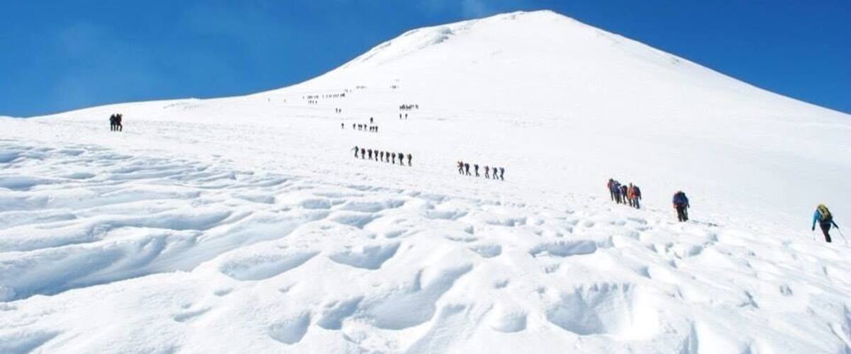 A snow-covered mountain with a clear blue sky.