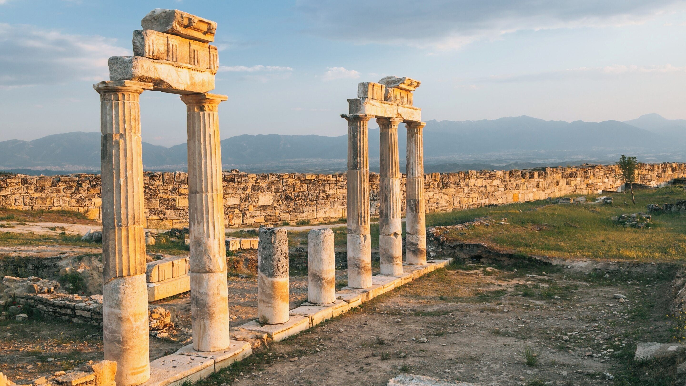 Ruins of Hierapolis in Pamukkale, Denizli Province showcasing ancient columns against the scenic backdrop of the Turkish landscape at sunset