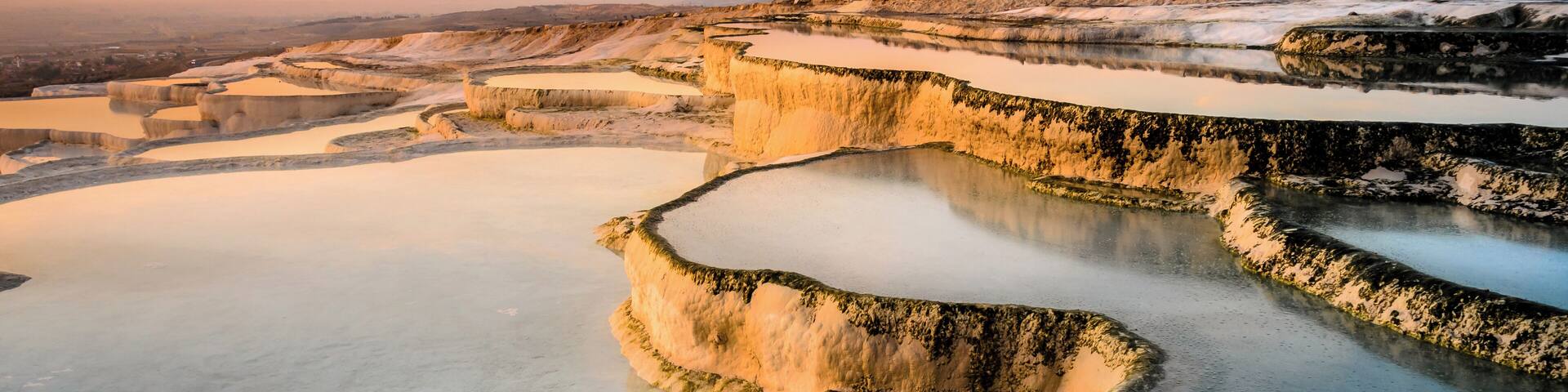 Terraced mineral pools at sunset.