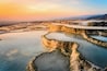 Terraced mineral pools at sunset.