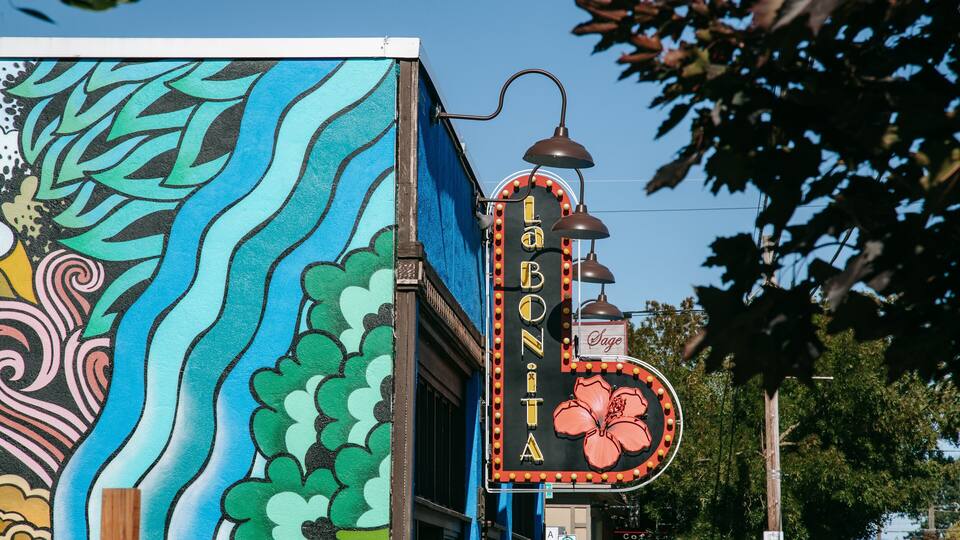 A colorful mural with a stylized flower and the text "LABONITA" on a building.