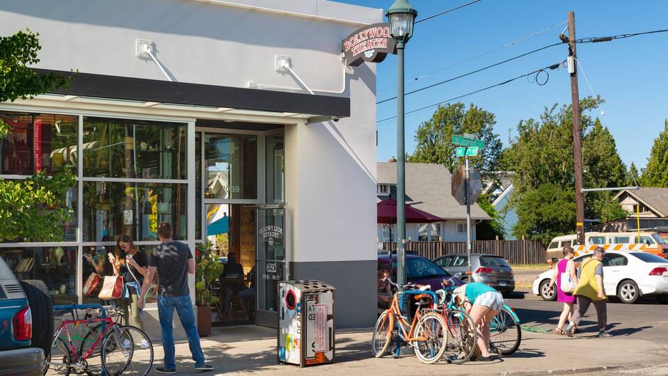 A storefront with a sign reading "Bollywood Theater," bicycles parked outside, and a street with cars and pedestrians.