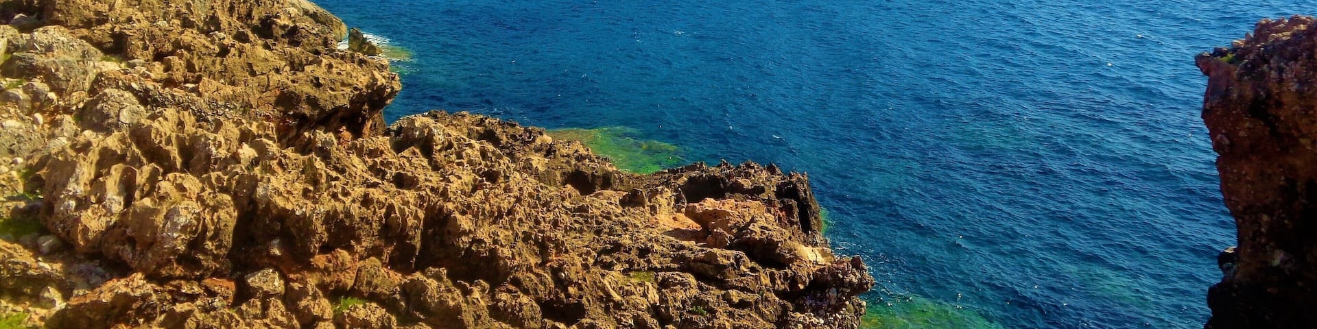 I took this photo in Messinia, Greece in summer 2016. It's of Voidokilia Beach and it's surroundings. Voidokilia Beach is on the Peloponnese peninsula and it was the most picturesque beach that I visited during that Greek trip, which was almost exclusively in Messinia. On that mountain is Nestor's Cave and above this are the ruins of a 13th-century Frankish castle (Old Navarino or Palaiokastro). Look closely and you will see :). I didn't get to walk up there. It was brutally hot that day and I spent most of the time at the beach. But, I did make time for some hiking. Near where I took this photo there was a lot of medieval or ancient ruins. Near those beautiful rocks. I had to be careful when walking on them, but it was worth it!