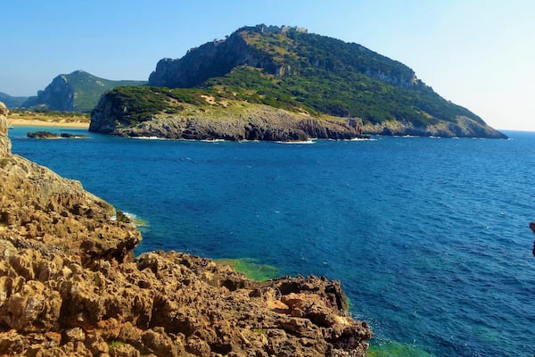 I took this photo in Messinia, Greece in summer 2016. It's of Voidokilia Beach and it's surroundings. Voidokilia Beach is on the Peloponnese peninsula and it was the most picturesque beach that I visited during that Greek trip, which was almost exclusively in Messinia. On that mountain is Nestor's Cave and above this are the ruins of a 13th-century Frankish castle (Old Navarino or Palaiokastro). Look closely and you will see :). I didn't get to walk up there. It was brutally hot that day and I spent most of the time at the beach. But, I did make time for some hiking. Near where I took this photo there was a lot of medieval or ancient ruins. Near those beautiful rocks. I had to be careful when walking on them, but it was worth it!