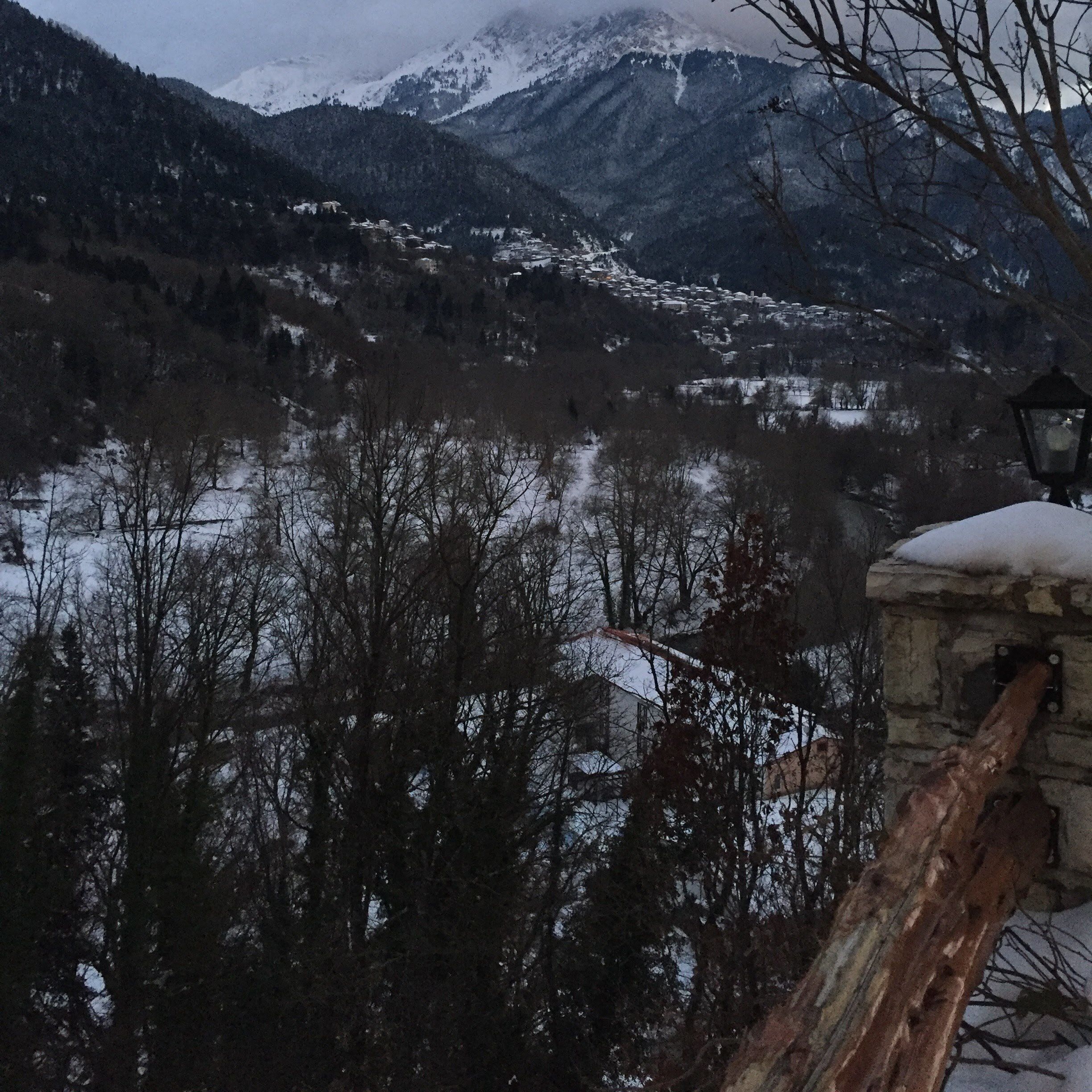 A snowy mountain landscape with a village in the valley.