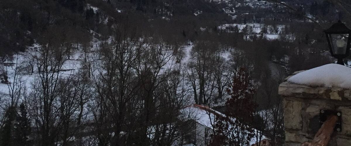 A snowy mountain landscape with a village in the valley.