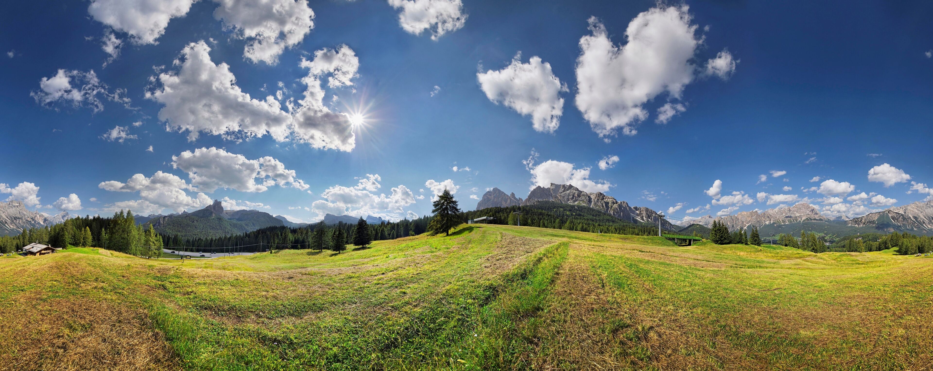 A mountainous landscape with a clear sky, a small house, and a distant castle.