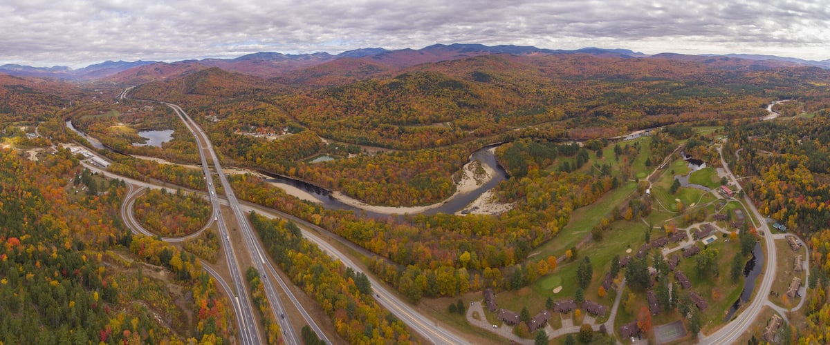 Interstate Highway 93 at Exit 30 with US Route 3 and Pemigewasset River in White Mountain National Forest panorama aerial view with fall foliage, Town of Thornton, New Hampshire NH, USA.