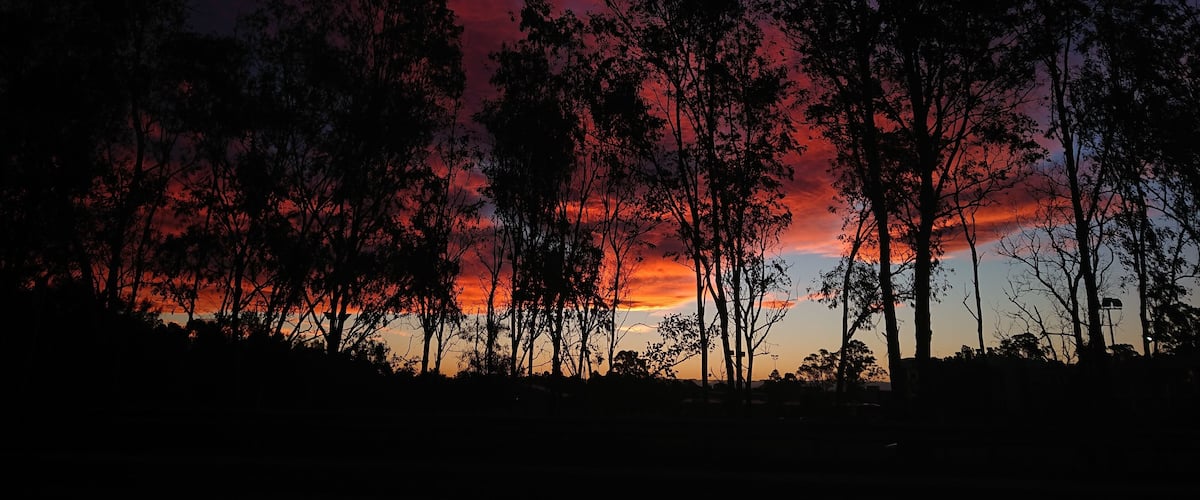Night sky with bush fire smoke lit up by low sunset.