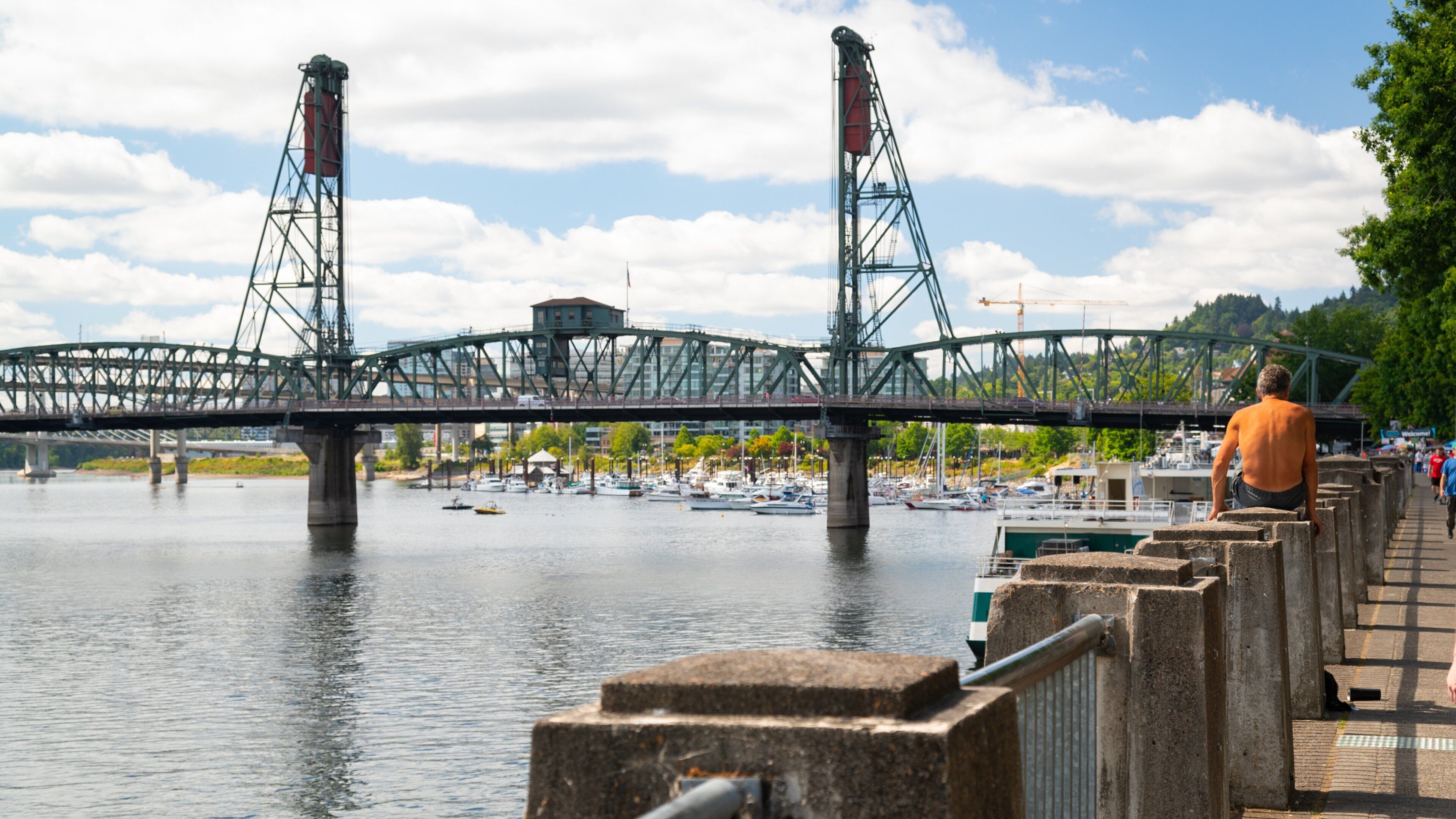 Hawthorne Bridge showing a river or creek and a bridge as well as an individual male