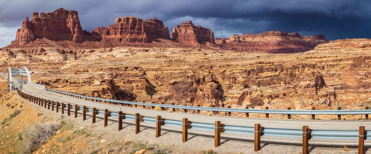 A winding road through a desert landscape with red rock formations.