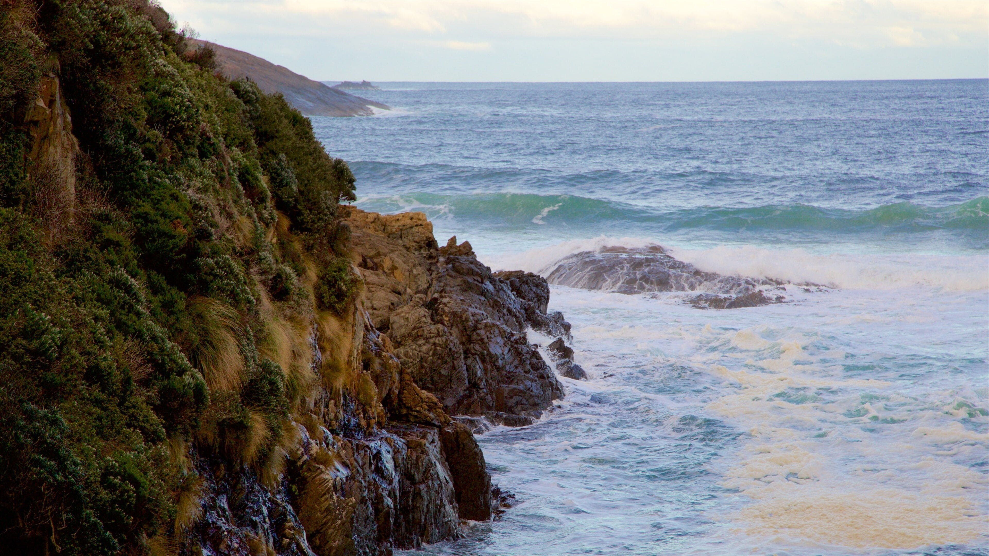 Remarkable Cave featuring waves and rocky coastline