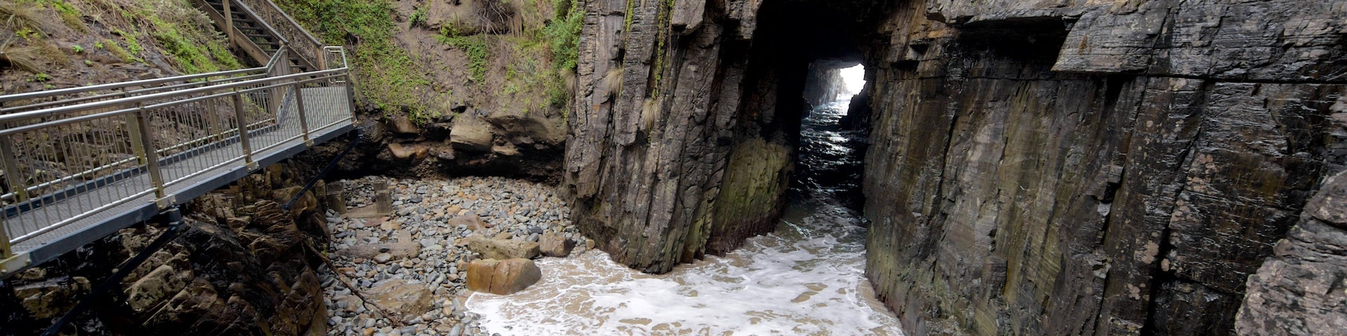 Remarkable Cave showing a sandy beach, rocky coastline and caves