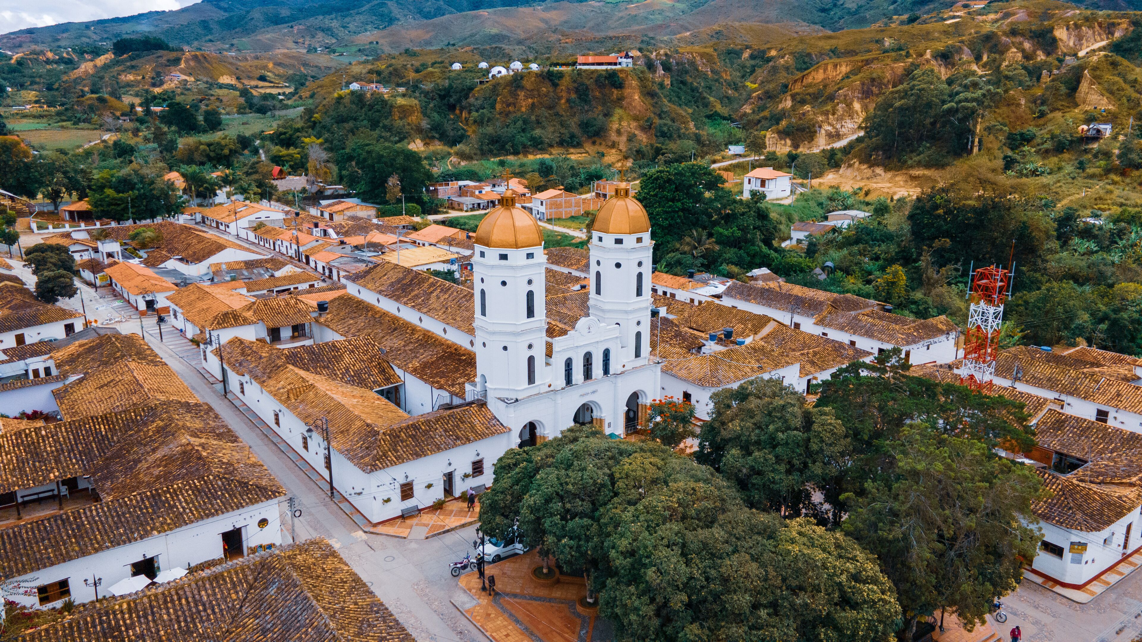 A town with white buildings and a prominent church with two towers.