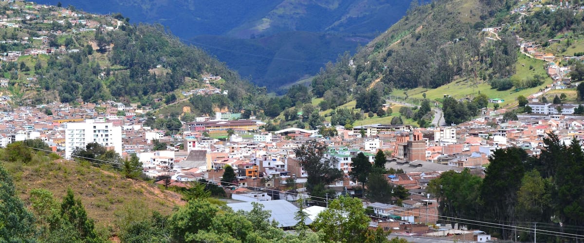 A town nestled in a valley with mountains in the background.