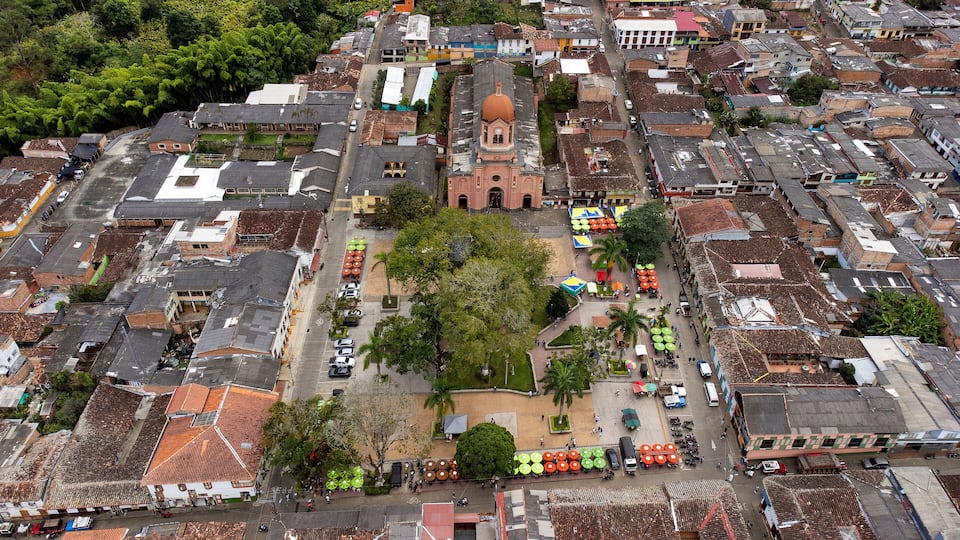 An aerial view of a densely packed urban area with a prominent church with a dome, surrounded by narrow streets and residential buildings.