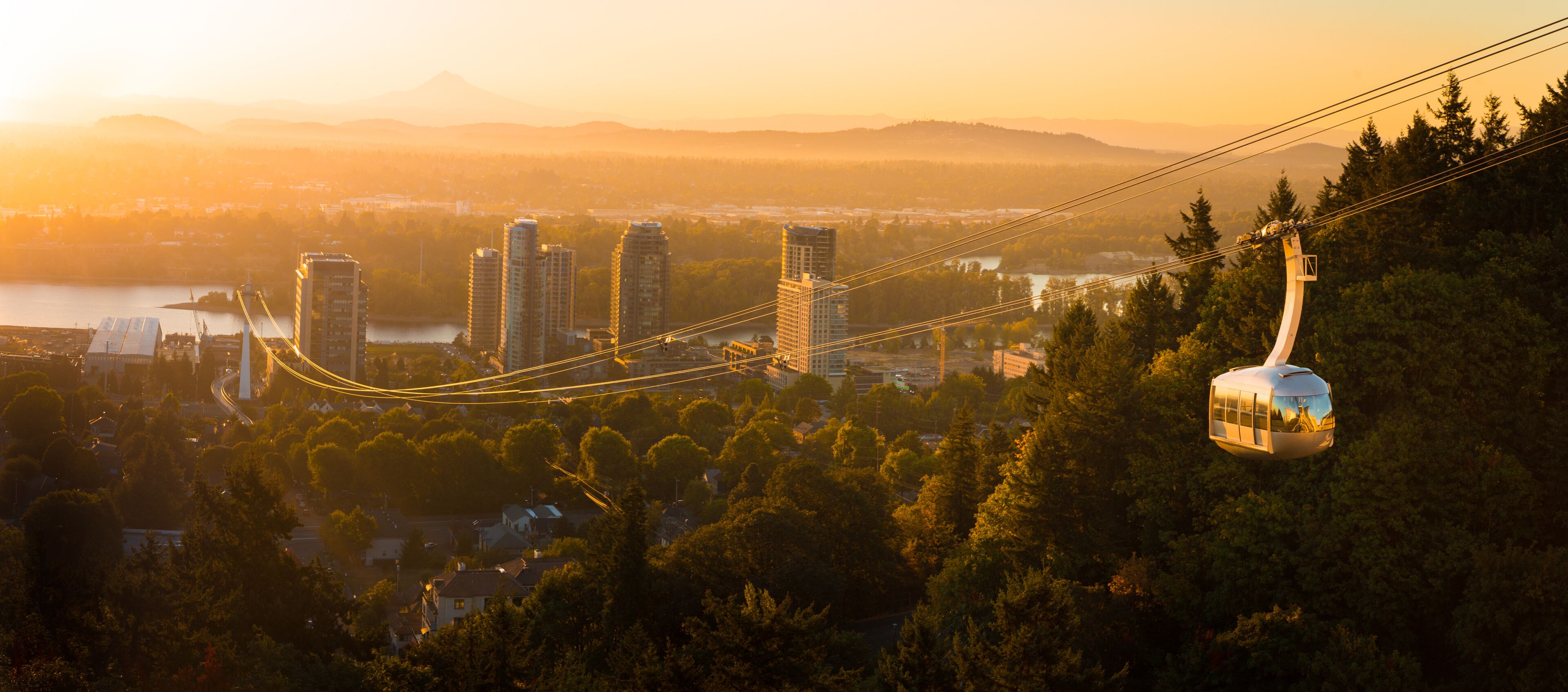 Cable car in Portland, Oregon, USA with wonderful view on sunrise with mt. Hood and aerial tram going to OHSU