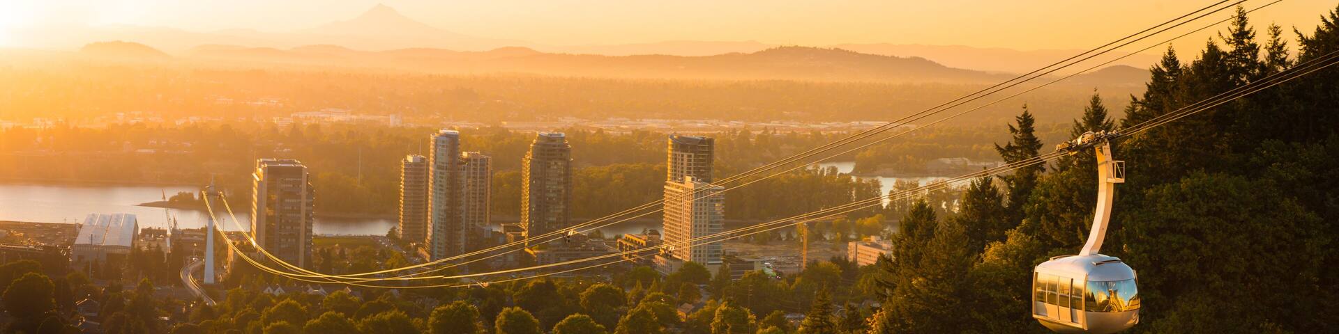 Cable car in Portland, Oregon, USA with wonderful view on sunrise with mt. Hood and aerial tram going to OHSU