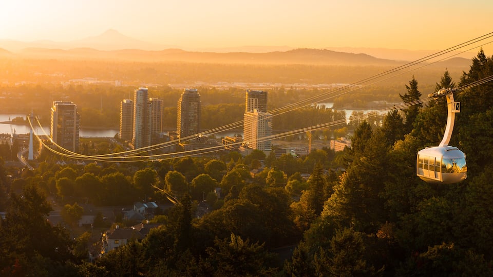 Cable car in Portland, Oregon, USA with wonderful view on sunrise with mt. Hood and aerial tram going to OHSU