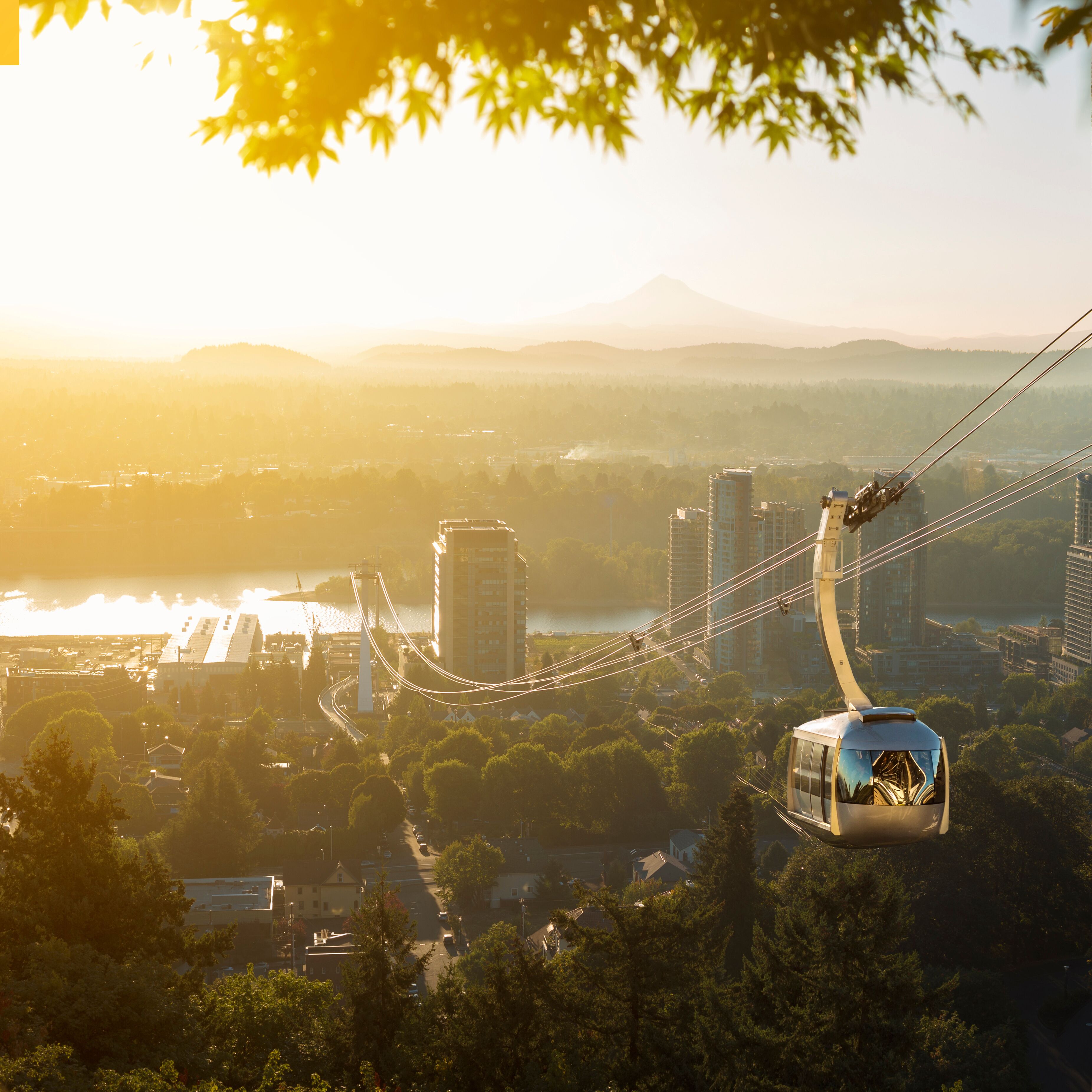 Cable car in Portland, Oregon, USA with wonderful view on sunrise with mt. Hood and aerial tram going to OHSU