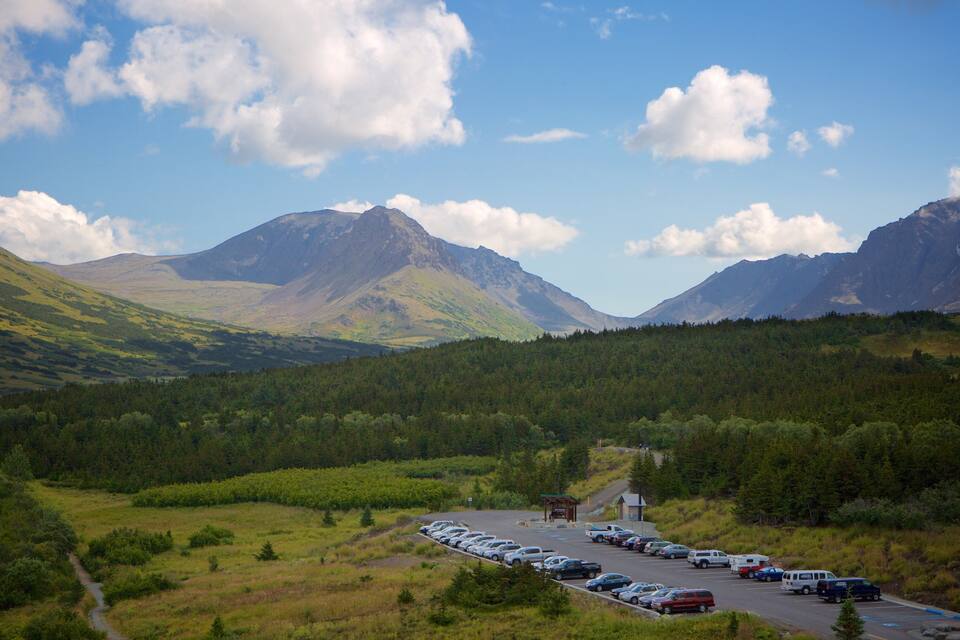A mountainous landscape with a parking lot and vehicles.
