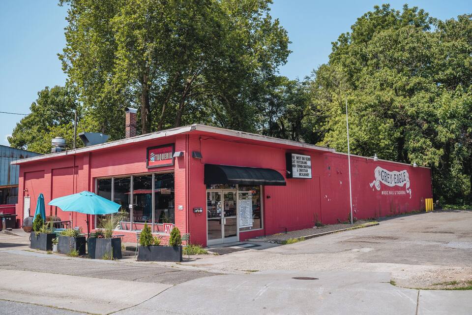 A red building with a blue awning and outdoor seating.