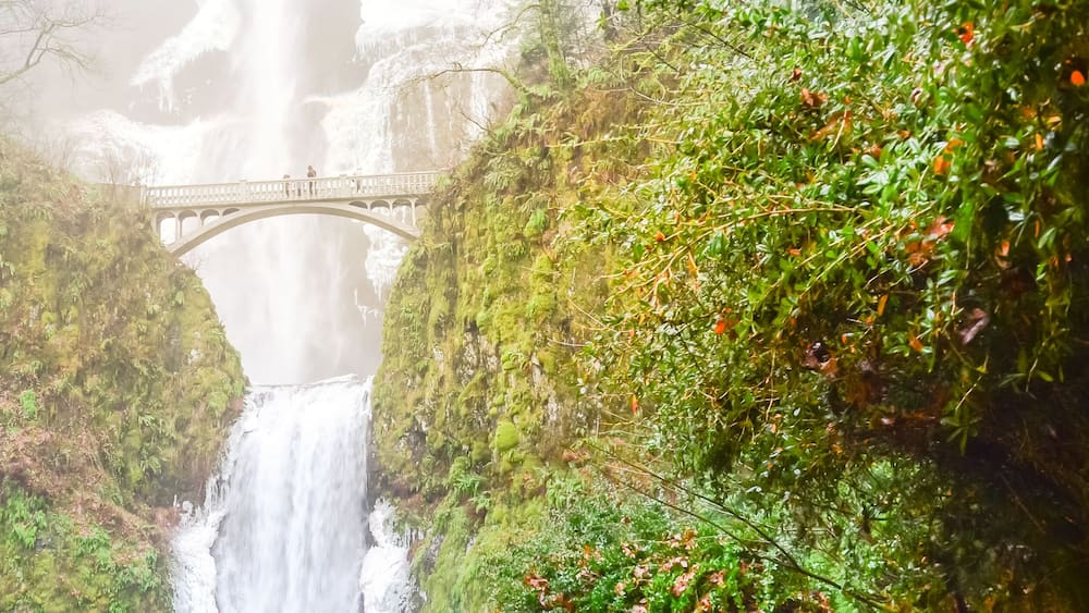 Panorama icy Multnomah Falls in winter time. It is a waterfall on the Oregon side of the Columbia River Gorge, along the Historic Columbia River Highway. Natural and seasonal waterfall background