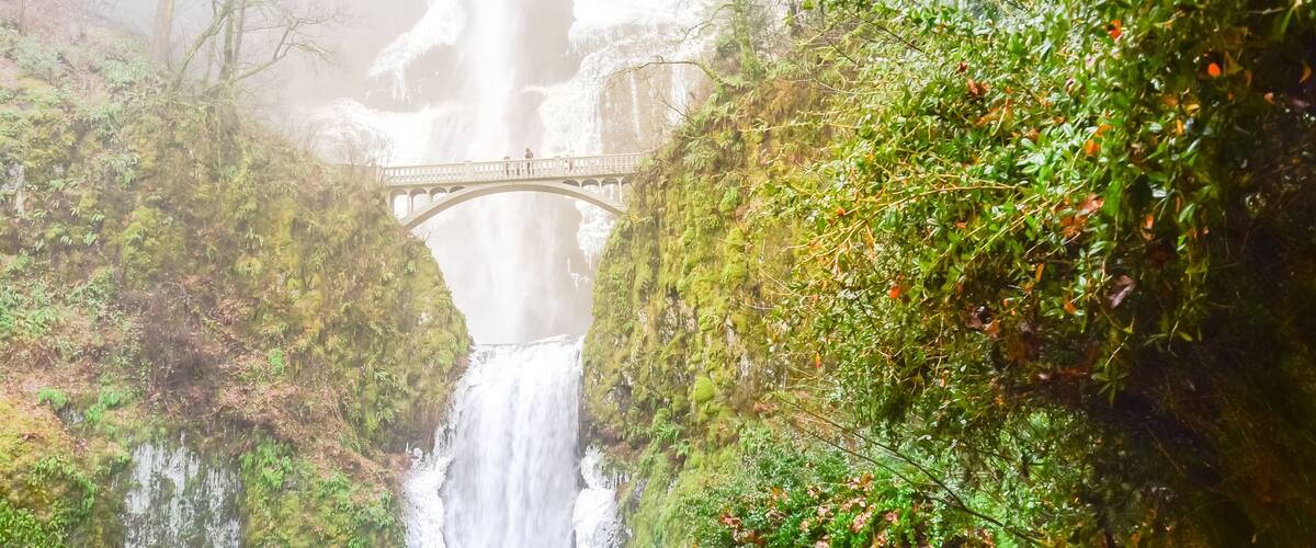 Panorama icy Multnomah Falls in winter time. It is a waterfall on the Oregon side of the Columbia River Gorge, along the Historic Columbia River Highway. Natural and seasonal waterfall background