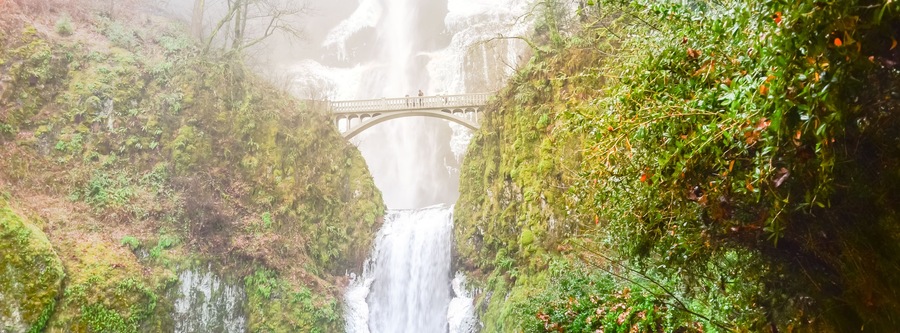 Panorama icy Multnomah Falls in winter time. It is a waterfall on the Oregon side of the Columbia River Gorge, along the Historic Columbia River Highway. Natural and seasonal waterfall background