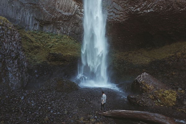A waterfall cascading down a rocky cliff surrounded by mossy terrain.