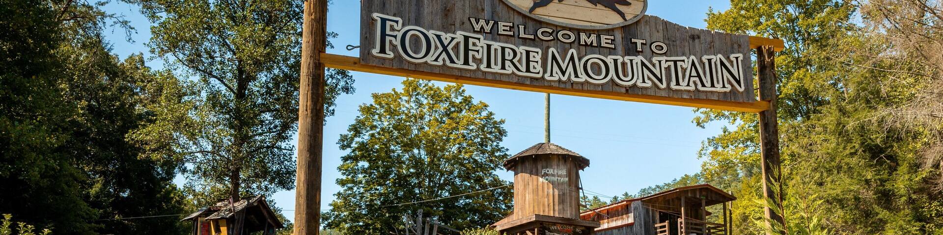 A wooden sign with a red fox and the text "Welcome to Foxfire Mountain".
