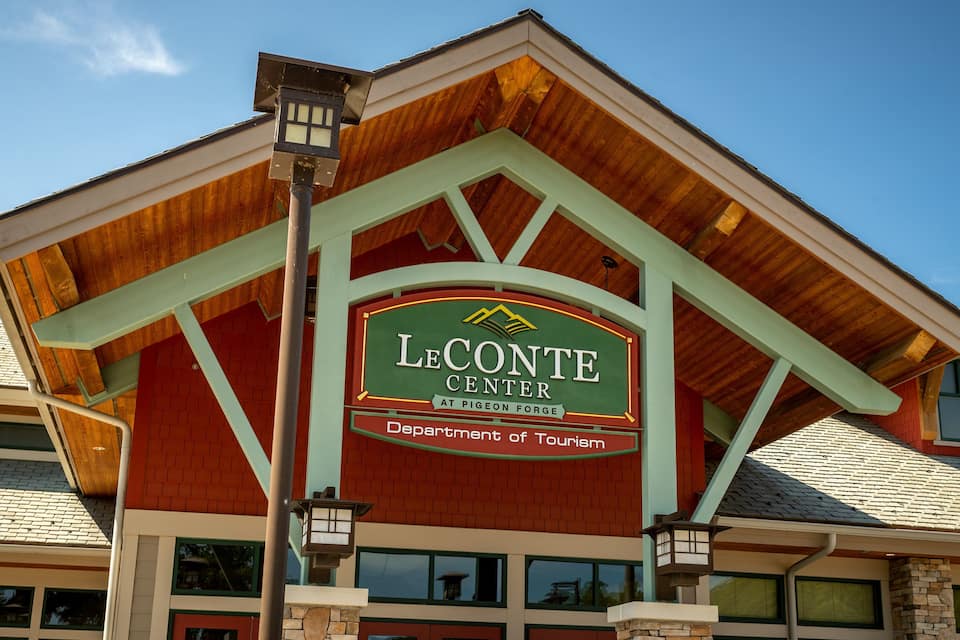 The LeConte Center building with a green roof and a sign indicating it is the Department of Tourism at Pigeon Forge.