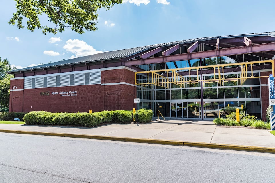 A building with a sign reading "Space Science Center" and a staircase leading to a glass entrance.
