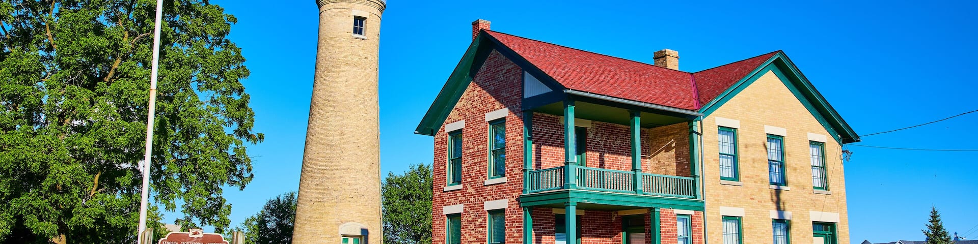 Historic Kenosha Lighthouse and Brick House with American Flag Daytime View