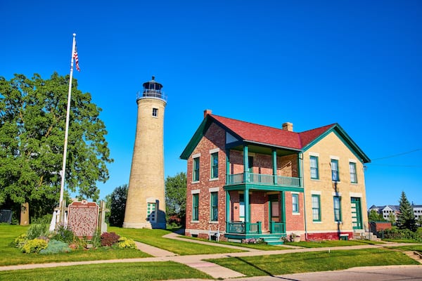 Historic Kenosha Lighthouse and Brick House with American Flag Daytime View