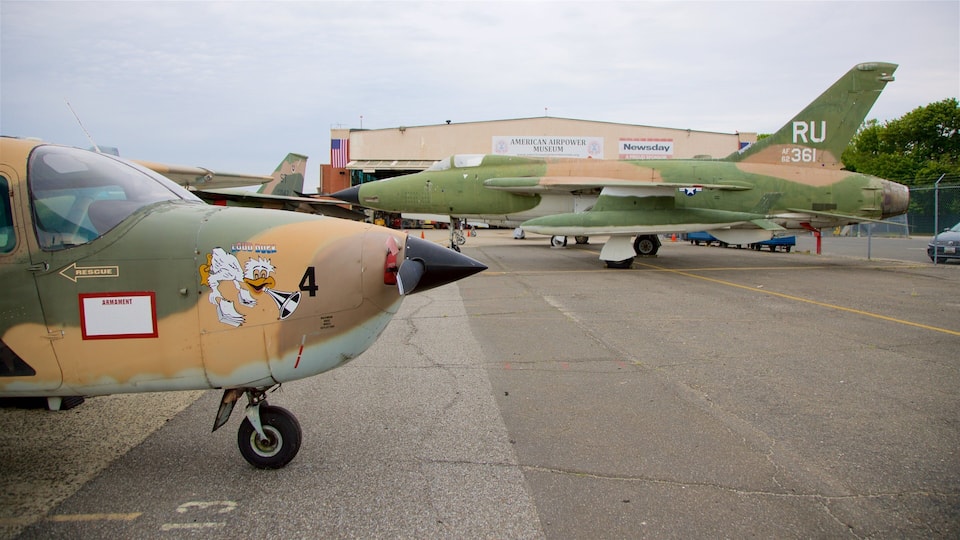 Military aircraft parked at an airfield with a building labeled "American Airpower Museum" in the background.