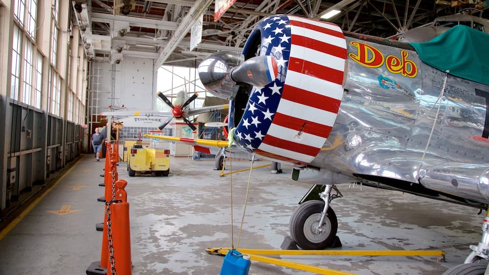 A vintage aircraft with a painted American flag on its side, inside a hangar.
