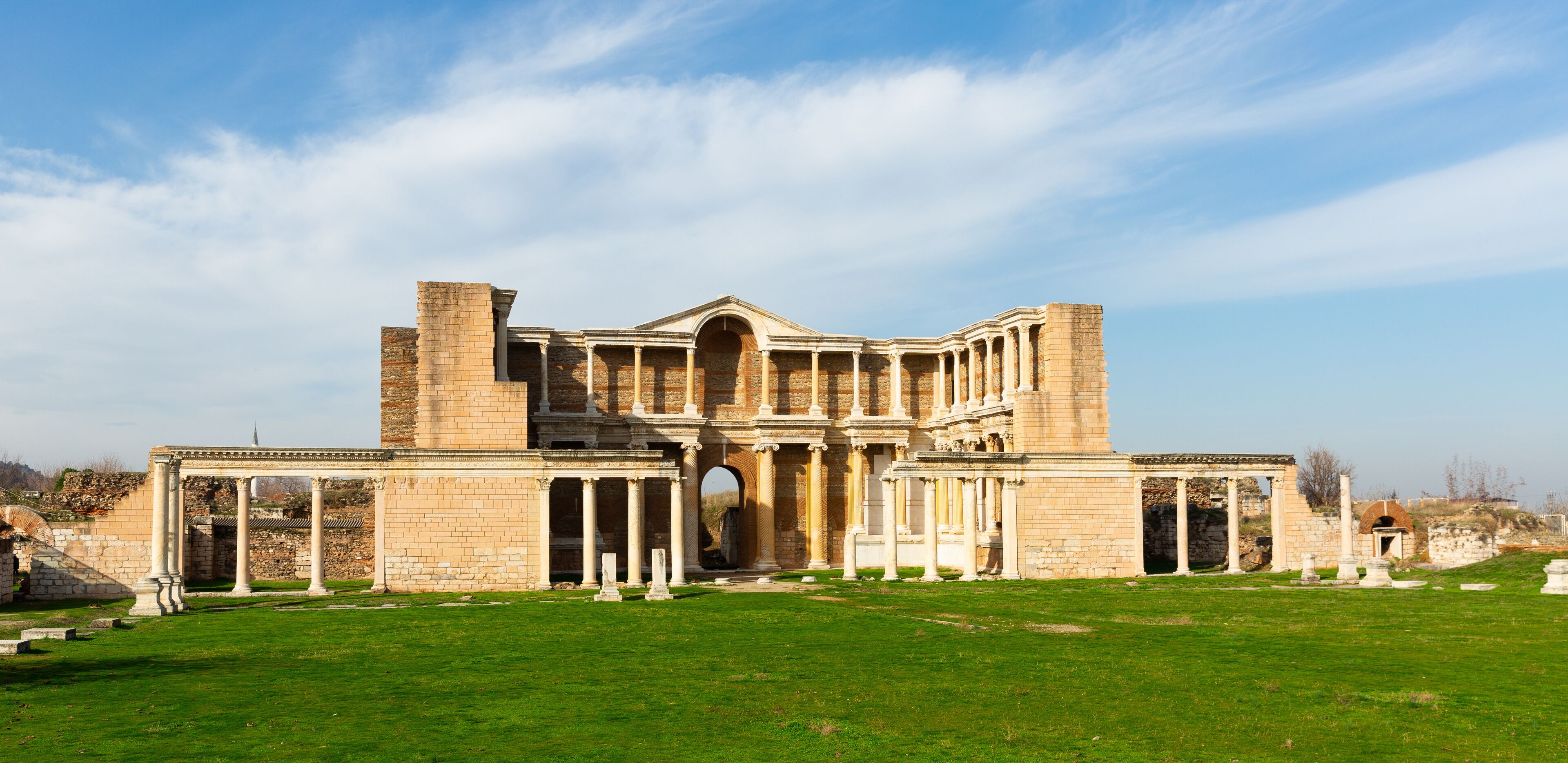 An ancient Roman amphitheater with columns and arches.