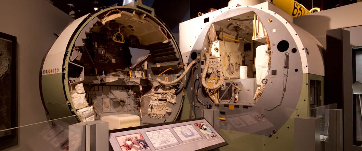 A space shuttle simulator with a control panel and a display of the interior.