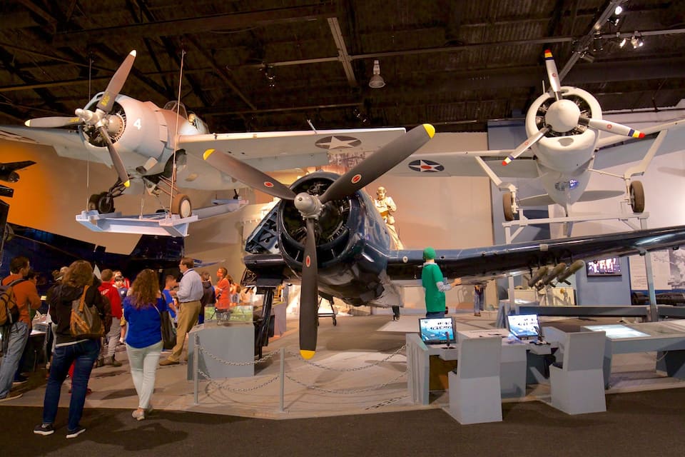 A museum exhibit with multiple aircraft on display, including a fighter jet and a bomber.