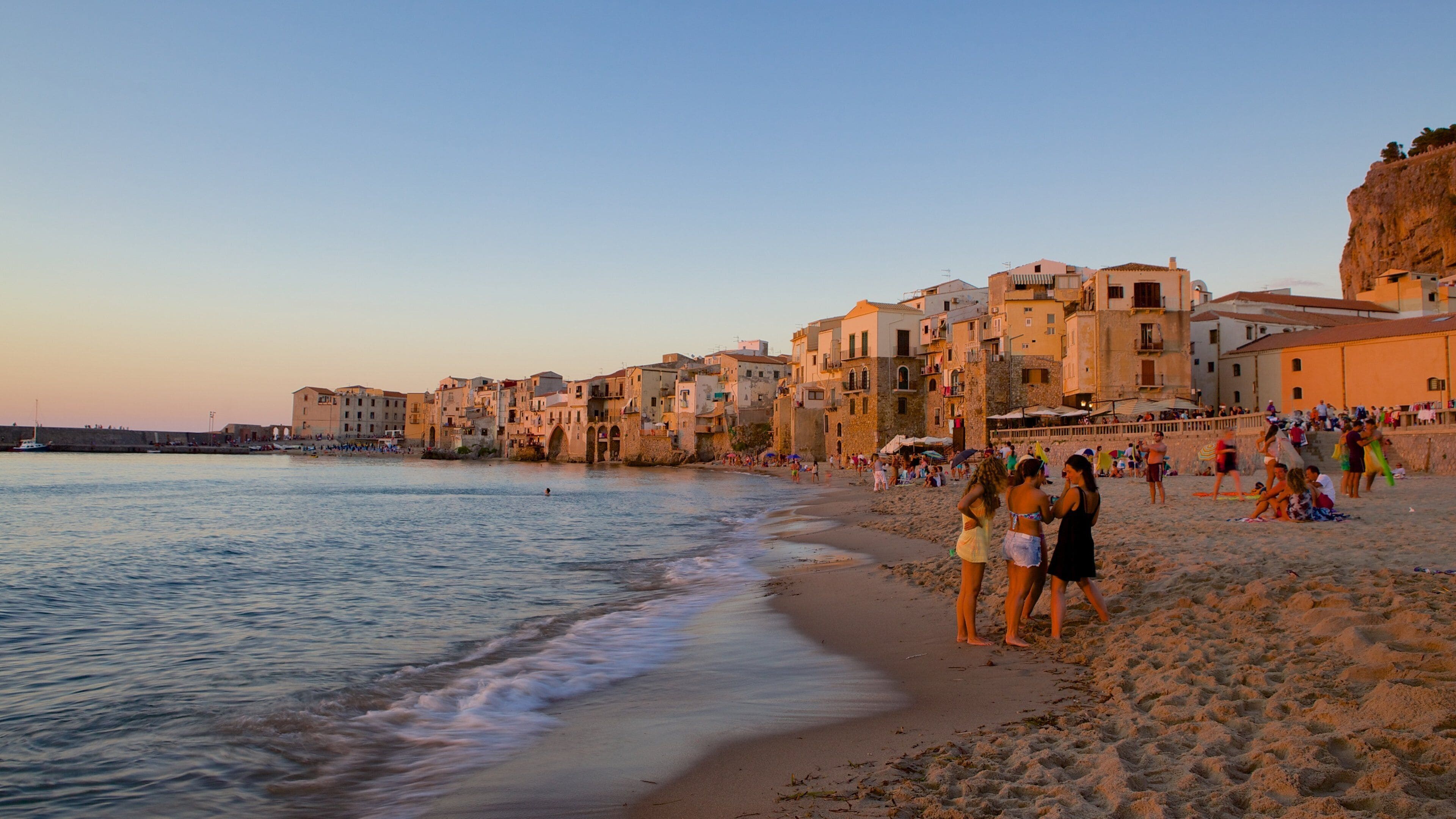 Rocca of Cefalu which includes a coastal town and a beach as well as a small group of people